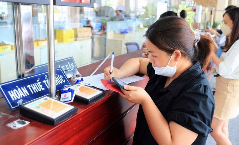 Nhân viên cửa hàng lập tờ khai hoàn thuế cho khách mua túi hiệu